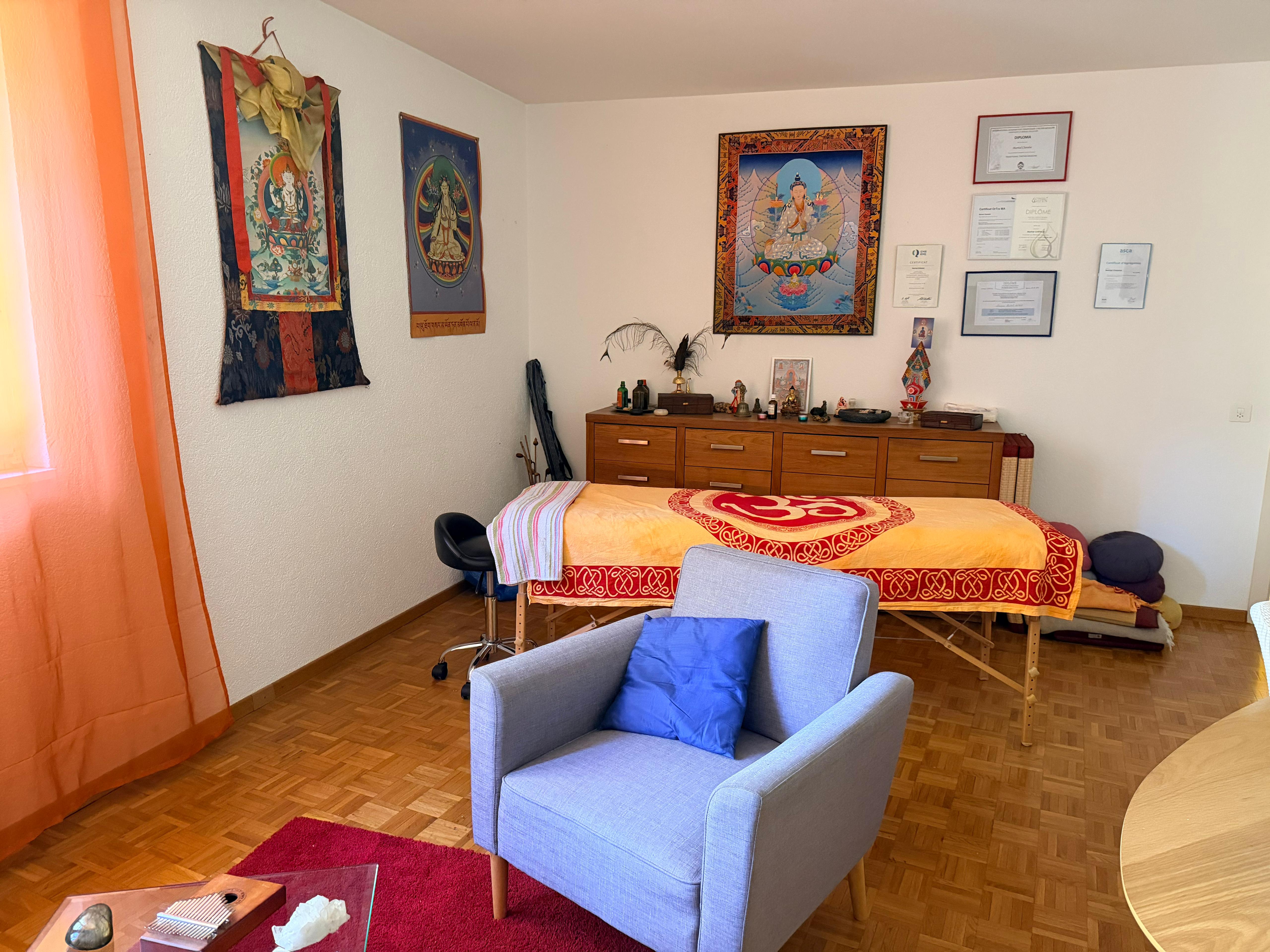 Le cabinet au Centre de Thérapies, rue du Rhône 11 à Sion : table de massage et tangkas tibétains